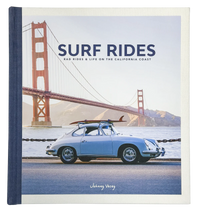 Book cover for Surf Rides by Johnny Vacay features a vintage blue car with a surfboard atop, highlighting rugged surf gear, parked near the Golden Gate Bridge under a sunny blue sky.