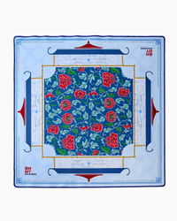 Oh My Mahjong’s Mahjong Mats feature a square neoprene design with a central blue floral pattern of red and pink flowers, a blue and gold border, and sections with light blue text and Mahjong motifs on white.