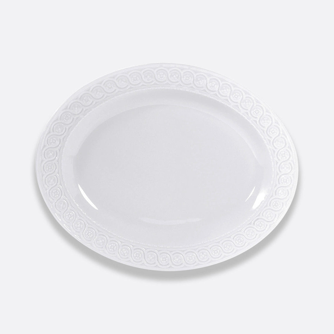 The Bernardaud Louvre Dinnerware features an empty white oval plate with an embossed rim, inspired by Renaissance elegance and French architecture—a refined piece for elegant white table settings.