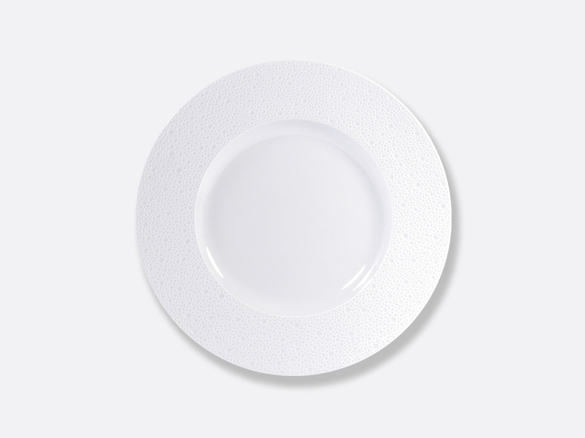 The Bernardaud Ecume White Dinnerware plate, made of Limoges porcelain with a subtly textured wide rim, is shown from above on a plain light gray background.