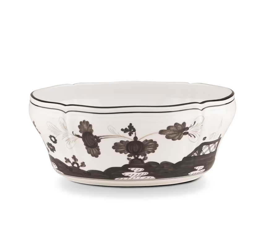 The Oriente Italiano Dinnerware Albus by Ginori 1735 is a white ceramic bowl handcrafted in Italy, featuring scalloped edges and decorated with black floral and abstract designs.