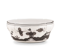 The Oriente Italiano Dinnerware Albus by Ginori 1735 is a white ceramic bowl handcrafted in Italy, featuring scalloped edges and decorated with black floral and abstract designs.