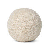 The Angelite Cushion 10" by Natures Collection is a round, beige pillow with a soft woolly texture—resembling plush or sherpa—perfect for modern decor, shown against a plain white background.