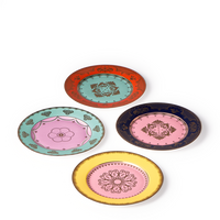 The Polspotten Grandpa Canape Plates Multi Set of 4 features porcelain side plates with ornate gold designs on white, each in a unique color—red, green, dark blue, and yellow—and arranged in a diamond shape.