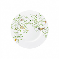 The Raynaud Histoire Naturelle Dinnerware features a white plate adorned with green leafy branches, rare birds, and colorful butterflies on the rim for a beautifully nature-inspired dining experience.