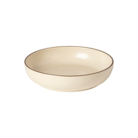 The Casafina/Costa Nova Pacifica Dinnerware Monterosa Beige features a round, shallow, cream-colored ceramic bowl with a thin brown rim, displayed against a plain white background.