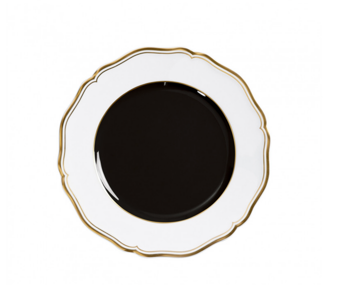 A round Mazurka Dinnerware Or Black plate by Raynaud, featuring a scalloped white rim, gold trim, and glossy black center, is displayed from above on a white background—showcasing refined French craftsmanship.
