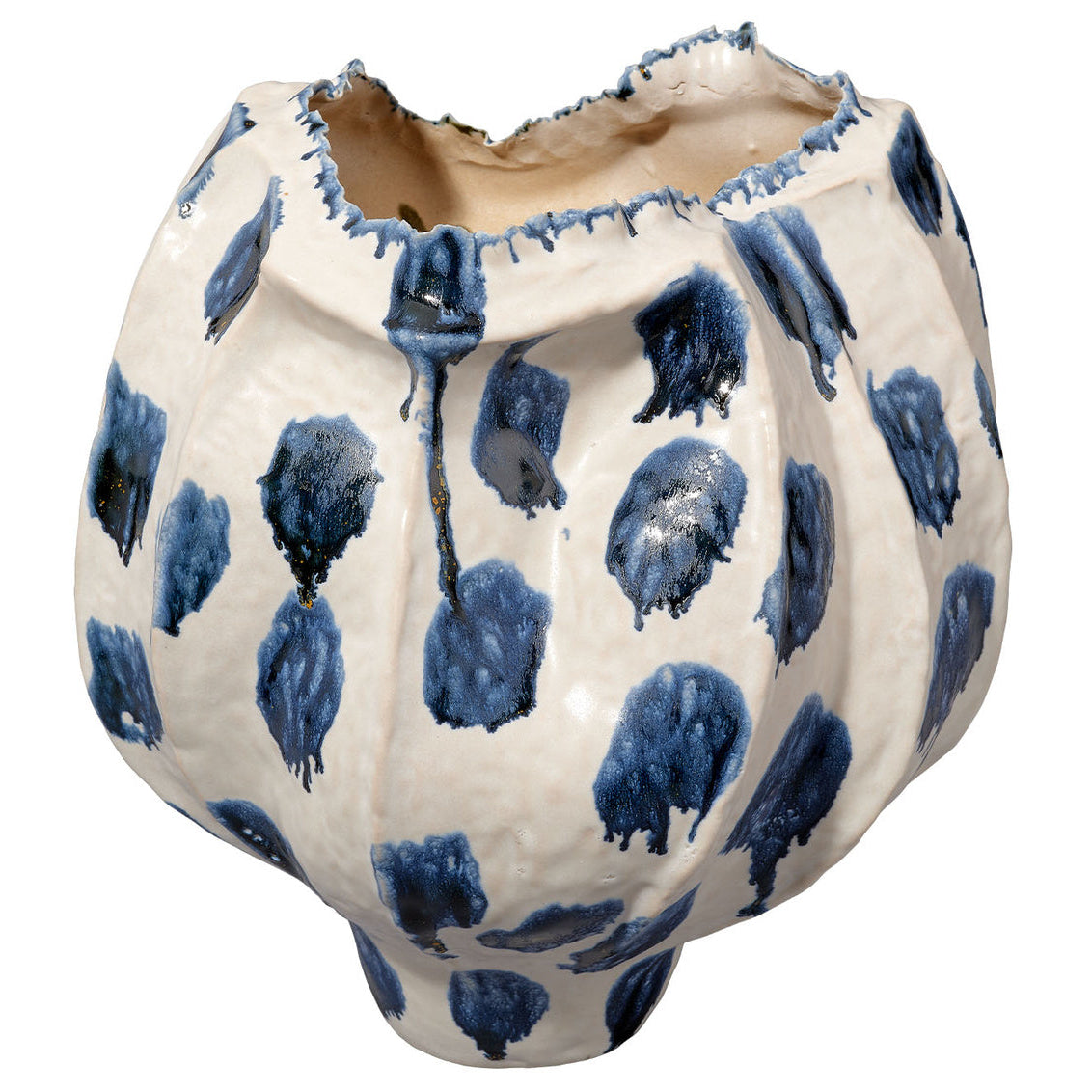 The Moncler Blue Vase by Jamie Young is a white ceramic piece with an uneven, jagged rim, featuring large blue reactive glaze spots and drips for a handcrafted, organic look.
