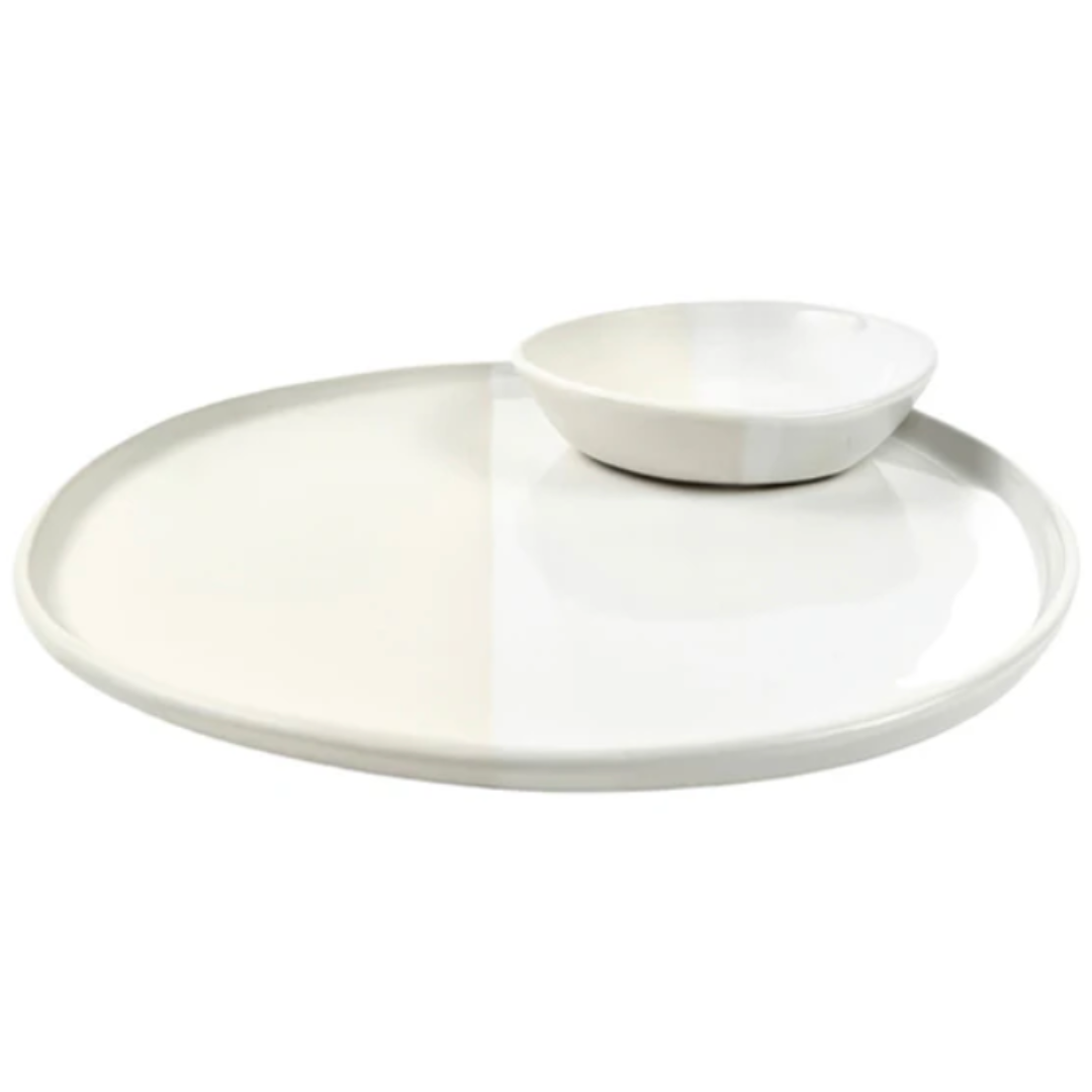 The Alex Marshall Studios Urban Round Platter 13" features a large, modern white design reminiscent of handcrafted artisan pieces—perfect for serving with a smaller bowl on top.