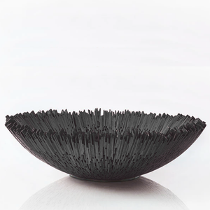 The Boracay Centerpiece Bowl is a handcrafted, shallow bowl in dark wood with a jagged, textured rim resembling upright shards.