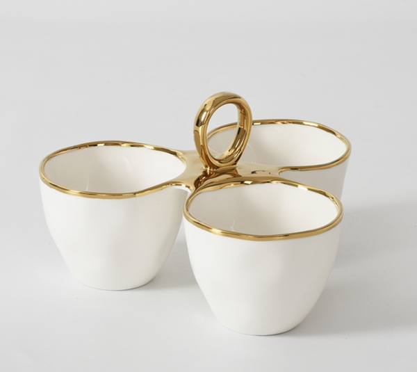 The PAMPA BAY Golden Handle 3 Section Server features three white porcelain bowls with gold rims, joined in a triangle with a central gold handle for easy carrying. A standout from the elegant oven to table collection, shown on a plain white background.