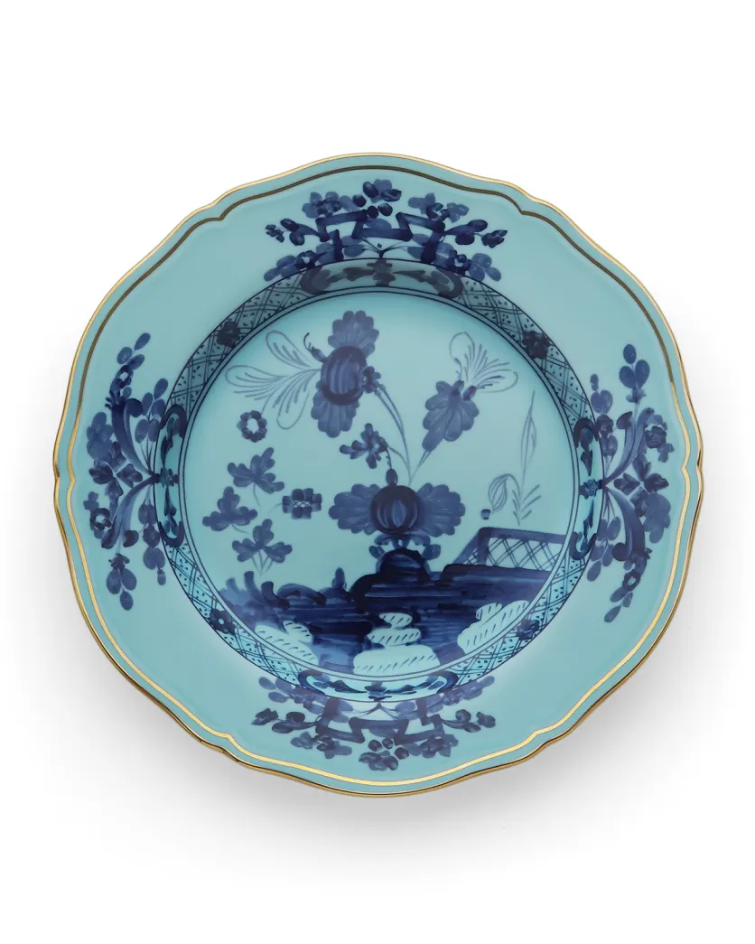 The Oriente Italiano Dinnerware Iris plate by Ginori 1735 features a blue chinoiserie floral motif with scalloped edges and a gold rim on white porcelain.