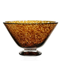 The Vanessa Tortoise Bowl by William Yeoward is a wide, shallow glass bowl with a small pedestal base and a mottled amber-brown tortoiseshell pattern that beautifully catches and reflects light. Part of the William Yeoward Vases and Bowls collection.