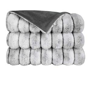 The Summit Throw by D.V. KAP / Canaan Company features a thick, folded gray faux fur texture on one side and smooth dark gray fabric on the other, shown against a white background.