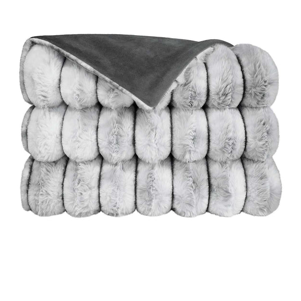 The Summit Throw by D.V. KAP / Canaan Company features a thick, folded gray faux fur texture on one side and smooth dark gray fabric on the other, shown against a white background.