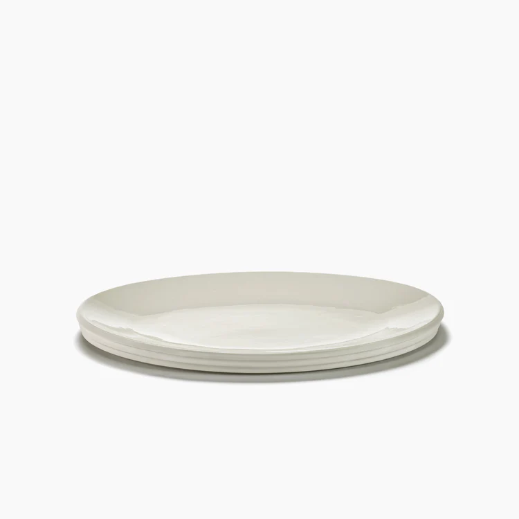 The Serax Dune Oval Platter Alabaster - 18" features a sleek, minimalist design. Three of these elegant white ceramic platters are stacked neatly against a plain white background.