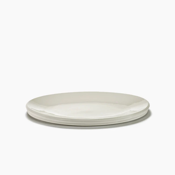 The Serax Dune Oval Platter Alabaster - 18" features a sleek, minimalist design. Three of these elegant white ceramic platters are stacked neatly against a plain white background.