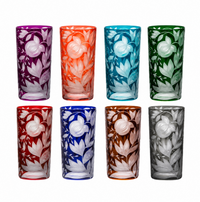 Eight Artel Verdure Highball Jewel Colors crystal glasses in different jewel tones, each featuring an etched floral pattern of pomegranates and leaves.