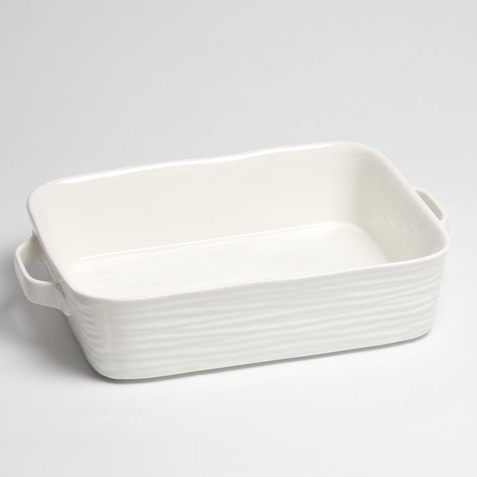 The PAMPA BAY Le Blanc Rectangle Baker, a glossy white ceramic dish with slightly wavy sides and two handles, rests on a plain white surface.