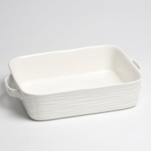 The PAMPA BAY Le Blanc Rectangle Baker, a glossy white ceramic dish with slightly wavy sides and two handles, rests on a plain white surface.