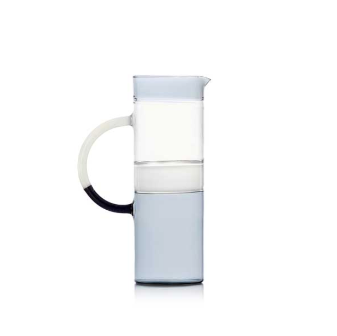 The Ichendorf Milano Tequila Sunrise Cylinder Pitcher, made from clear glass with a large curved handle and light blue base, is the perfect stylish cocktail pitcher for your barware setup. Shown on a plain white background.