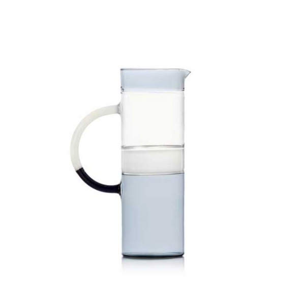 The Ichendorf Milano Tequila Sunrise Cylinder Pitcher, made from clear glass with a large curved handle and light blue base, is the perfect stylish cocktail pitcher for your barware setup. Shown on a plain white background.