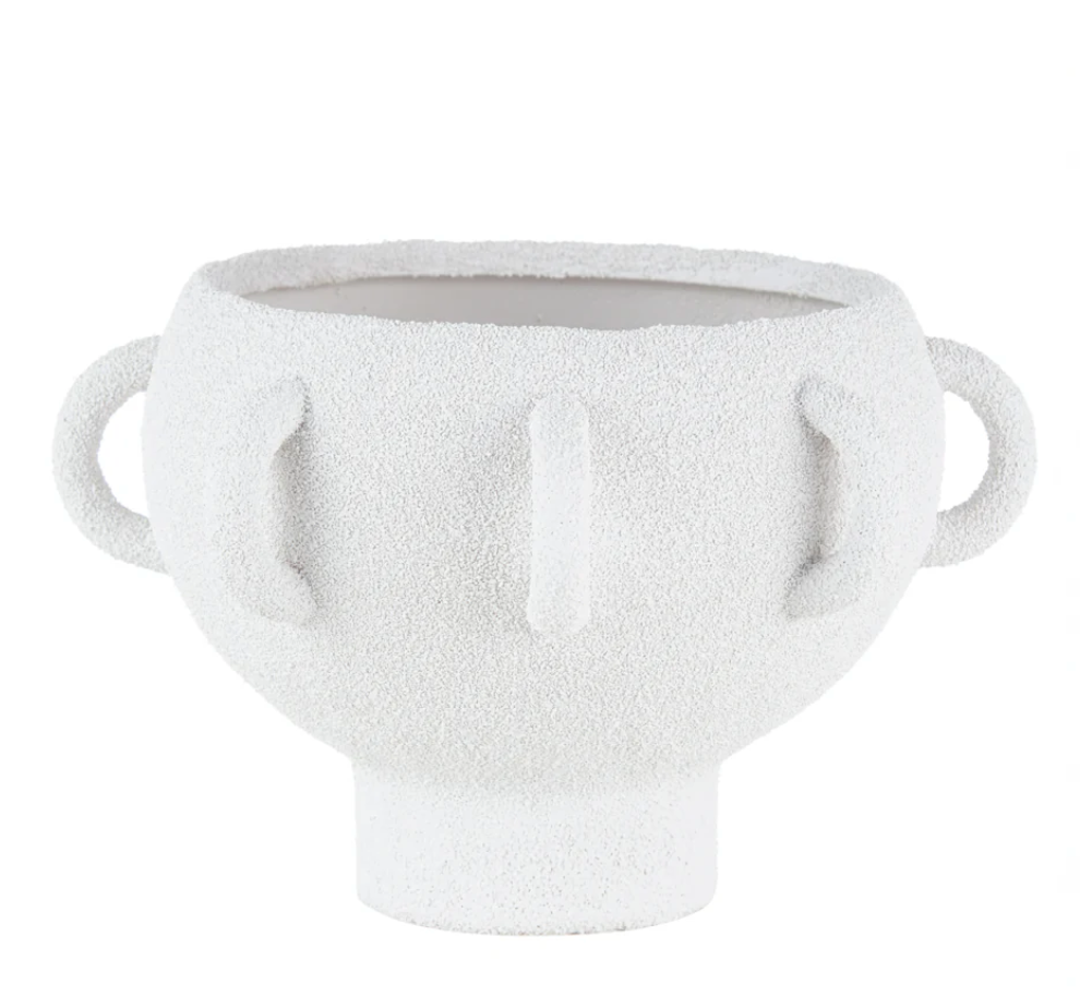 The BT- Shalom Textured Vessel White features a wide round porcelain body, two looped side handles, three vertical raised lines on the front, and a short cylindrical base.