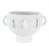 The BT- Shalom Textured Vessel White features a wide round porcelain body, two looped side handles, three vertical raised lines on the front, and a short cylindrical base.