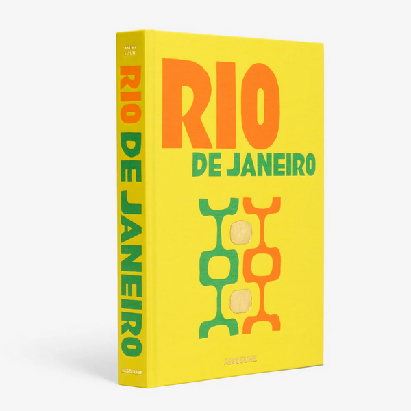 A bright yellow hardcover book, "Travel Series - Rio de Janeiro Viva" by Assouline, features bold orange and green text with abstract geometric designs on the front cover and stands upright with its spine visible.