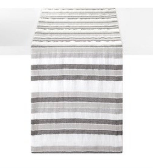 The Bodrum Aegean Stripe Runner 90" - Black, with horizontal gray and dark gray stripes, is elegantly displayed on a white table.