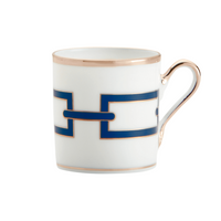 The Catene Zaffiro Dinnerware by Ginori 1735 features a white porcelain cup with gold-rimmed edges and handle, adorned with a blue geometric rectangular pattern inspired by Gio Ponti’s style—simple and elegant for any collection.