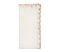 The Kim Seybert Arches Napkin Set of 4 features folded white linen napkins with wavy, scalloped edges, tan stitching, and embroidered detailing along one side.