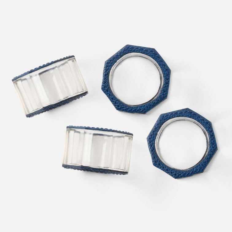 The Arthur Navy Napkin Ring Set of 4 by Blue Pheasant features octagonal crystal rings with clear centers and blue textured edges, arranged on a white background to show both side and top views.