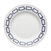 The Catene Zaffiro Dinnerware by Ginori 1735 is a white ceramic plate featuring a navy blue geometric rectangular pattern around the rim and a slim gold edge trim.