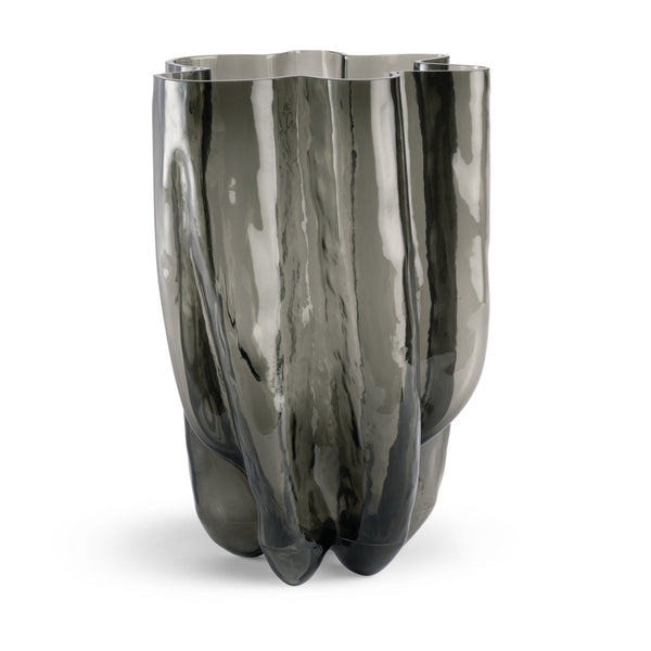 The Hudson Smoke Grey Vase by FlowDecor Inc. features a tall, sculptural design in smoky gray glass with a glossy finish, organic curves, and a wavy rim for striking modern decor.
