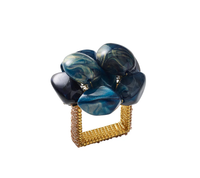 The Kim Seybert Bonton Napkin Ring Set of 4 in Navy & Gold features gold mesh rings topped with large, polished marbleized navy and gold beads, beautifully set against a white background.