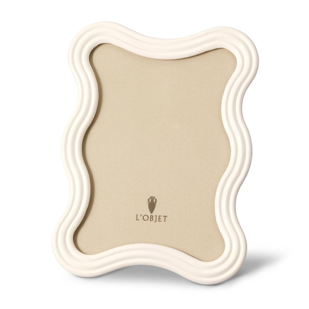 Ripple-edged, cream-colored Ripple Enamel Frame White by L'Objet with a neutral beige insert featuring the L'Objet logo at the center, displayed against a plain white background.