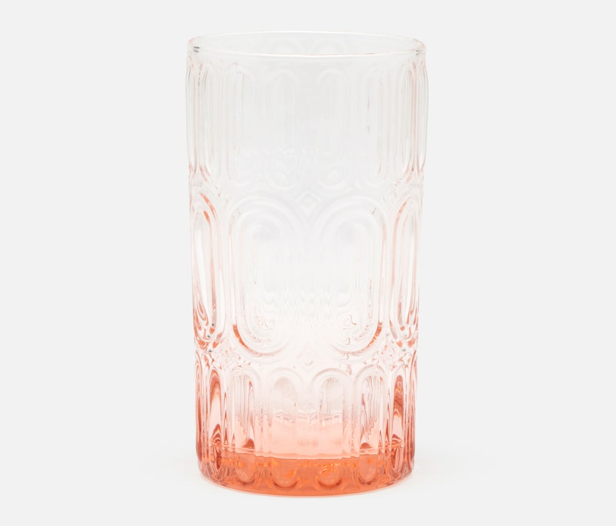 The Aaron Pink Glassware Set of 6 by Blue Pheasant features hand-blown glass tumblers with an embossed bangle pattern and a gradient from clear at the top to a light pinkish-orange base.