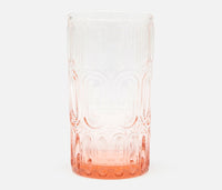 The Aaron Pink Glassware Set of 6 by Blue Pheasant features hand-blown glass tumblers with an embossed bangle pattern and a gradient from clear at the top to a light pinkish-orange base.