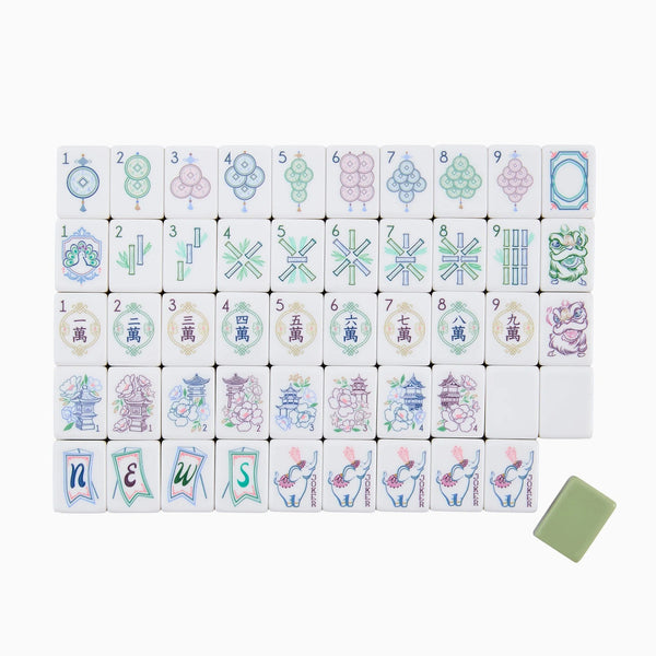 Mahjong tiles from the Oh My Mahjong Mahjong Tiles Set - Willow are arranged in rows, displaying circles, bamboo, characters, dragons, winds, flowers, and joker tiles. Among the floral tiles of this elegant set, a single green blank tile appears at the bottom right.
