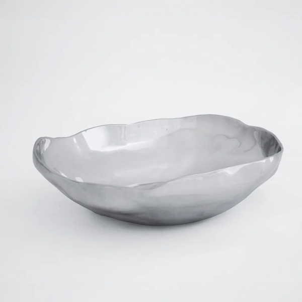 The Beatriz Ball Soho Nueve Organic Bowl 12.5" is a shiny, handcrafted metal bowl with smooth, curved edges and an irregular shape, shown on a plain white background.