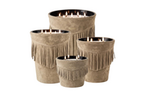 Four lit Baobab Calamity Jane Candle - The Plains in mineral taupe suede containers decorated with fringe.