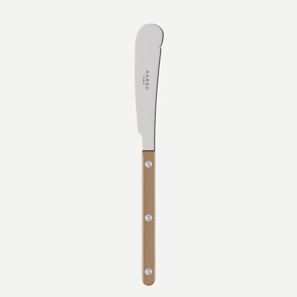 The Bistrot Pearly Butter Knife by Sabre features a curved, blunt stainless steel blade and a light brown handle with three metal rivets. Ideal for customizable flatware sets, the blade is engraved with “Sabre.”.