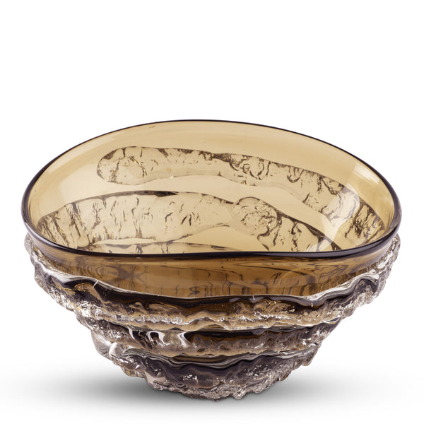The Modena Amber Bowl by FlowDecor Inc. is a round, amber-hued decorative bowl featuring a textured, layered exterior and a smooth, gently wavy rim, shown here against a white background.