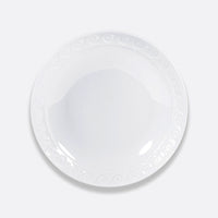 The Bernardaud Louvre Dinnerware features a white, round ceramic plate with a subtle swirl pattern along the rim, shown from above on a light gray background.