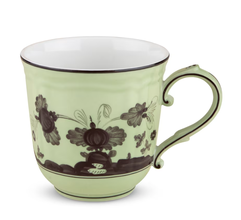 The Oriente Italiano Dinnerware Bario mug by Ginori 1735 is a light green ceramic piece with a curved handle, dark chinoiserie floral and insect motifs, and a white interior.