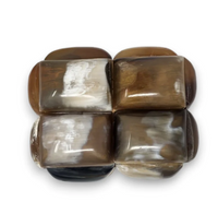 A Sanoma Inc’s Bubble Horn Box features six polished, rectangular brown and cream stones in two rows of three on a white background—ideal as whimsical decor or to display within the decorative Bubble Horn Box itself.