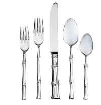 The Ricci Bamboo Flatware 5 Piece Setting includes two forks, a knife, a spoon, and a teaspoon with bamboo-inspired handles, all crafted from 18/10 stainless steel and shown on a white background.