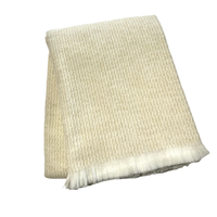 The Four Sided Pinstripe Fringe Throw by A Soft Idea is a folded cream wool blend scarf featuring subtle pinstripes and short fringe on one end, displayed against a white background.
