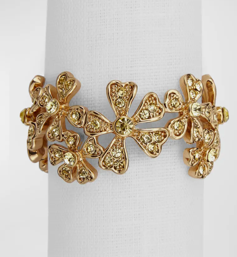 A 24K gold-plated floral bracelet with yellow gems and heart-shaped petals, displayed on a white stand. Ideal for gifting or to pair with L'Objet Garland Napkin Jewels Gold Set of 4.